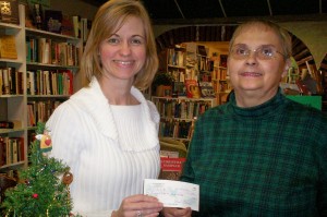 09novcasa Melanie Watkins (on left), Director of CASA, receives check from Judith Bartel, Book ReViews Accountant.