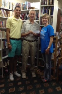 $1500 CASA Book ReViews Board Member Jim Loflin (center) presents a check to CASA Executive Director Melanie Babbitt (right) and intern Sean Leary (left)