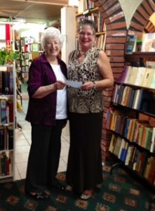 $2500 for Salvation Army's Harvest of Love Book ReViews volunteer Betty Schmidt (left) presents a check to Salvation Army Service Coordinator Marcia Brazil.