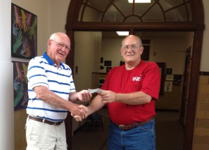 2013july1 Book ReViews board member Don Schmidt (L) hands check to Neal Schwabauer of HOPE Home Repair.